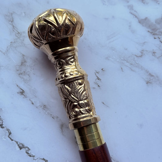 Decorative brass-handled walking cane on a marble surface