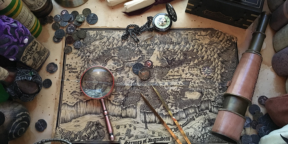 A photograph of the Steppes of Augrudeen prop map by Deven Rue with cartography tools and bottles surrounding it.